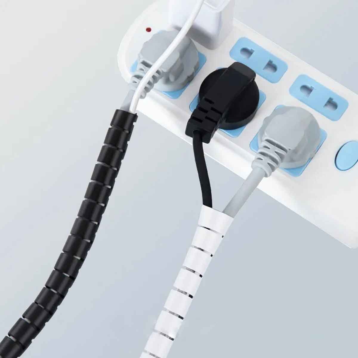 organizador blanco y negro de cables en un multicontacto